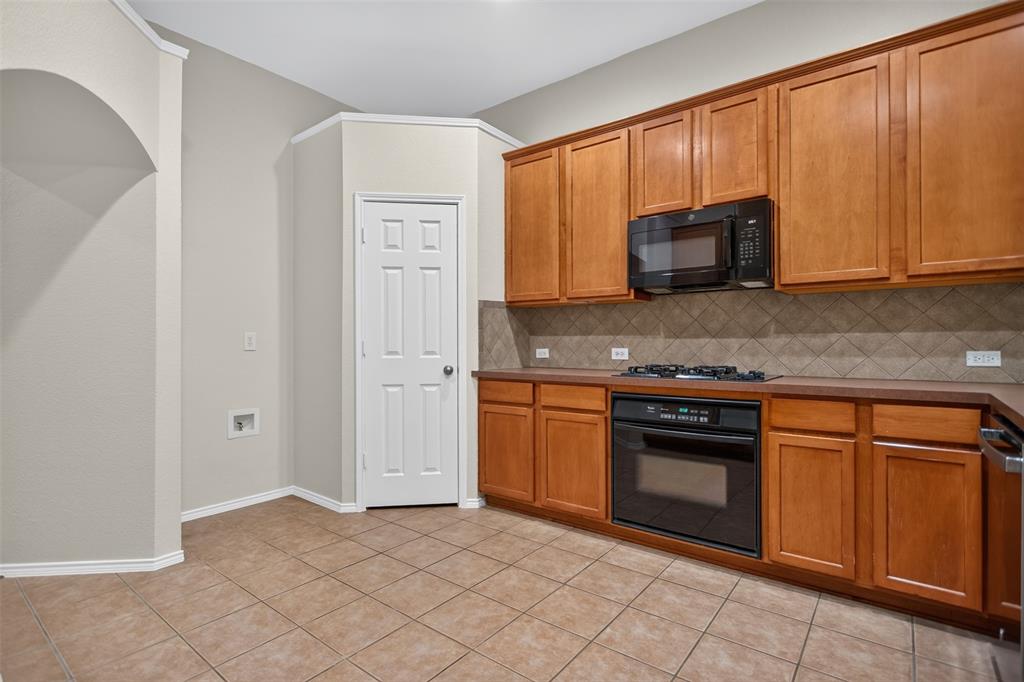 Kitchen featuring wood cabinetry, tile flooring, diagonal tile backsplash, built-in wall oven, and over-the-range microwave