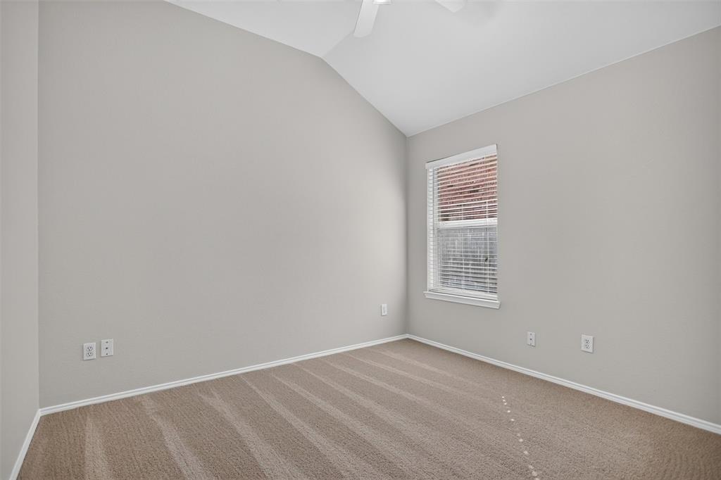 Vaulted ceilings, neutral wall tones, wall-to-wall carpeting, and a single-hung window with built-in blinds