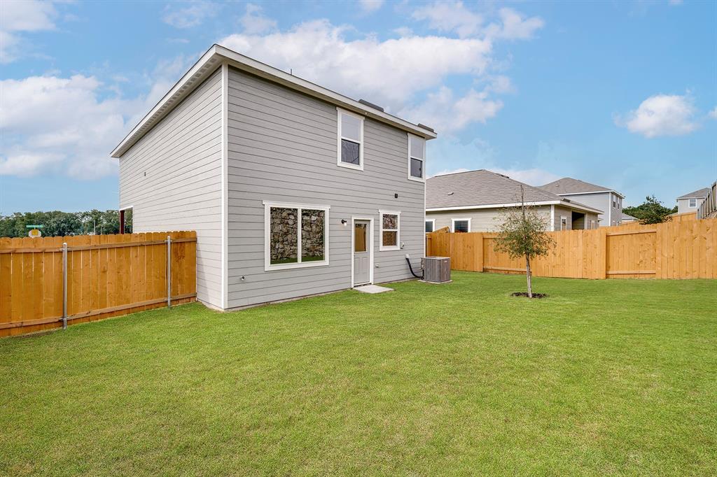 Rear view of property featuring a fenced backyard