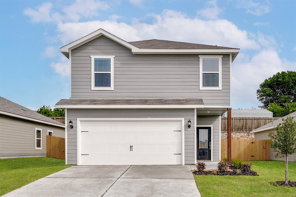 Traditional-style home with an attached garage, concrete driveway, and a shingled roof Traditional-style home with an attached garage, concrete driveway, and a shingled roof