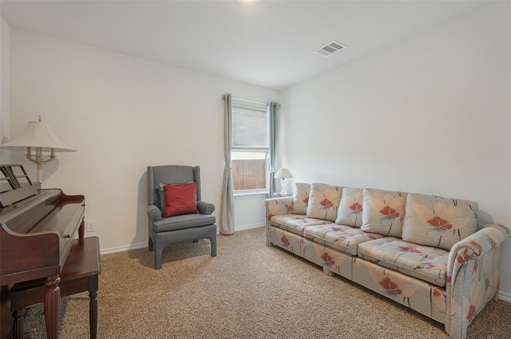 Neutral wall palette, carpeting, and a single window featuring horizontal blinds