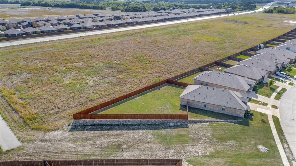 Expansive residential lot featuring an angular perimeter, private wood privacy fencing, and an elevated stone retaining wall