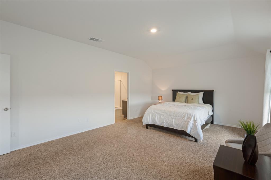 Neutral-toned carpeting, vaulted ceiling, and recessed lighting