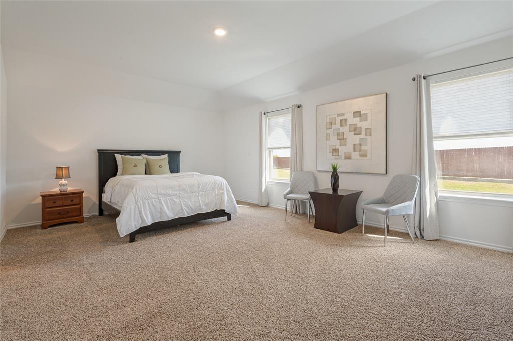 Spacious room featuring high ceilings, neutral wall-to-wall carpeting, and multiple windows with included hardware