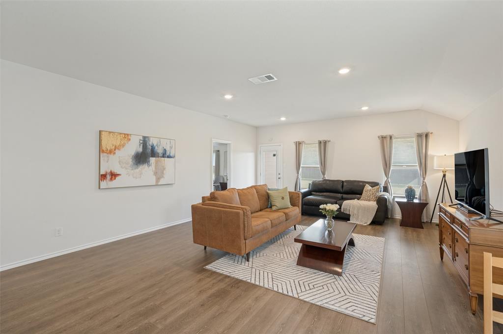 Neutral interior space featuring wood-finish flooring, high ceilings, and recessed lighting