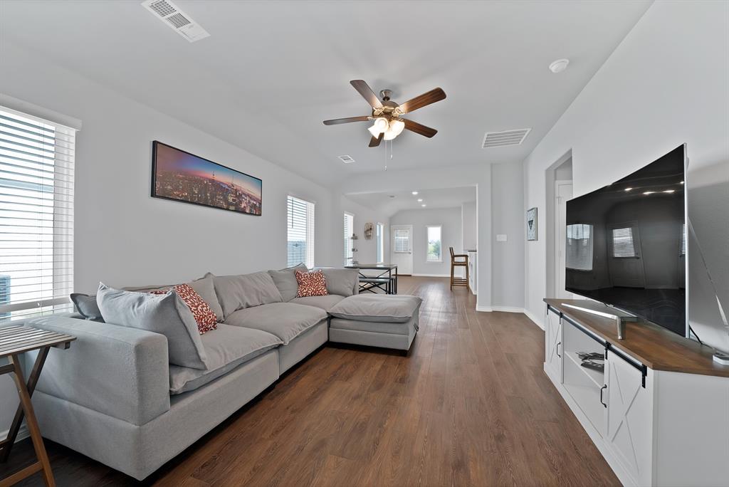 Interior living area featuring wood-finish flooring, recessed lighting, and a ceiling fan with integrated lighting