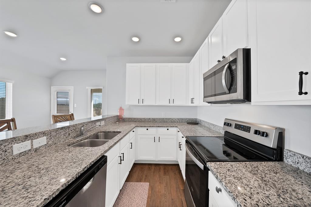 Kitchen featuring white cabinetry, stone-surface countertops, wood-finish flooring, stainless steel appliances, and recessed lighting