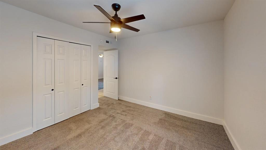 Neutral wall finish, wall-to-wall carpeting, bi-fold closet doors, and a ceiling fan with integrated lighting