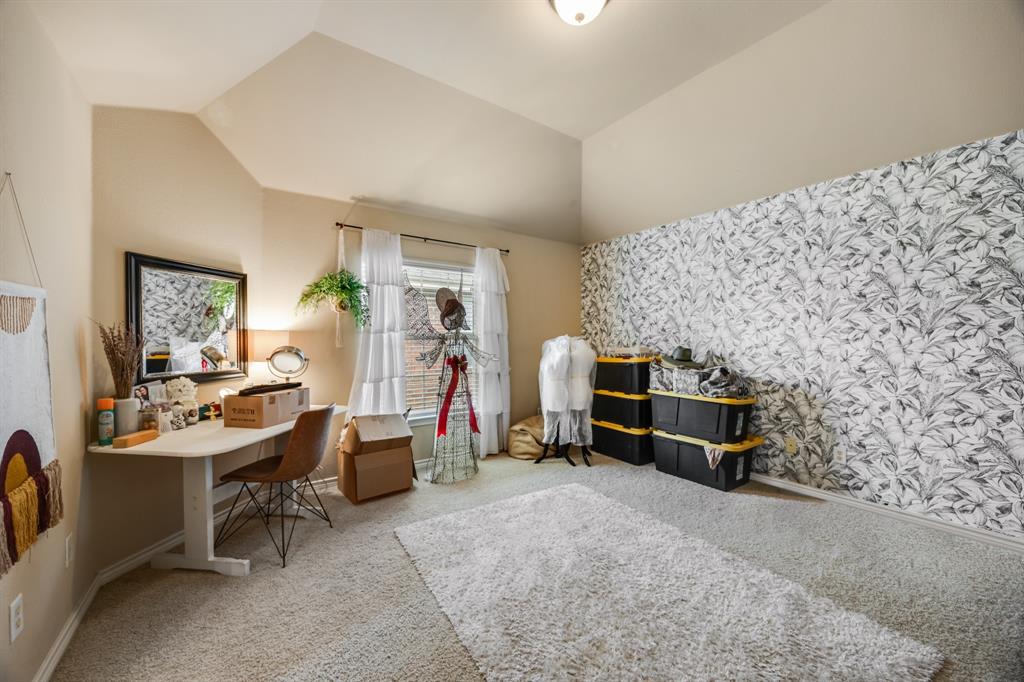 Office space with light colored carpet and vaulted ceiling