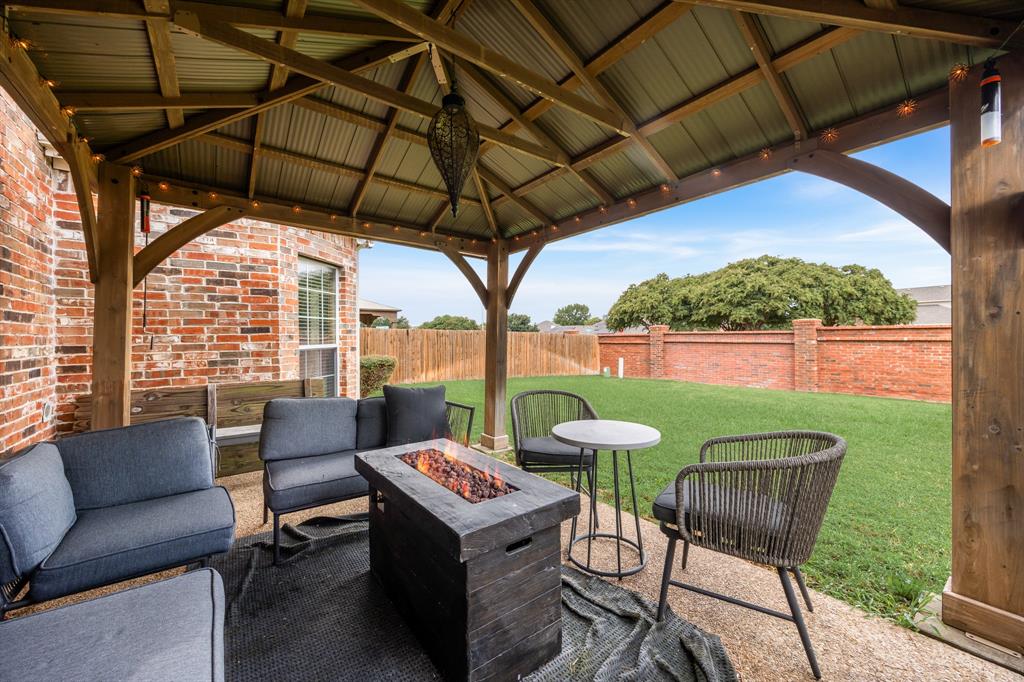 Fenced backyard featuring an outdoor living space with a fire pit and a patio area