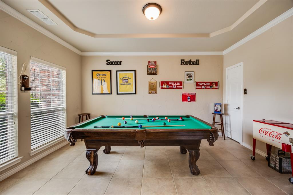 Game room featuring a raised ceiling, billiards, ornamental molding, and tile patterned flooring