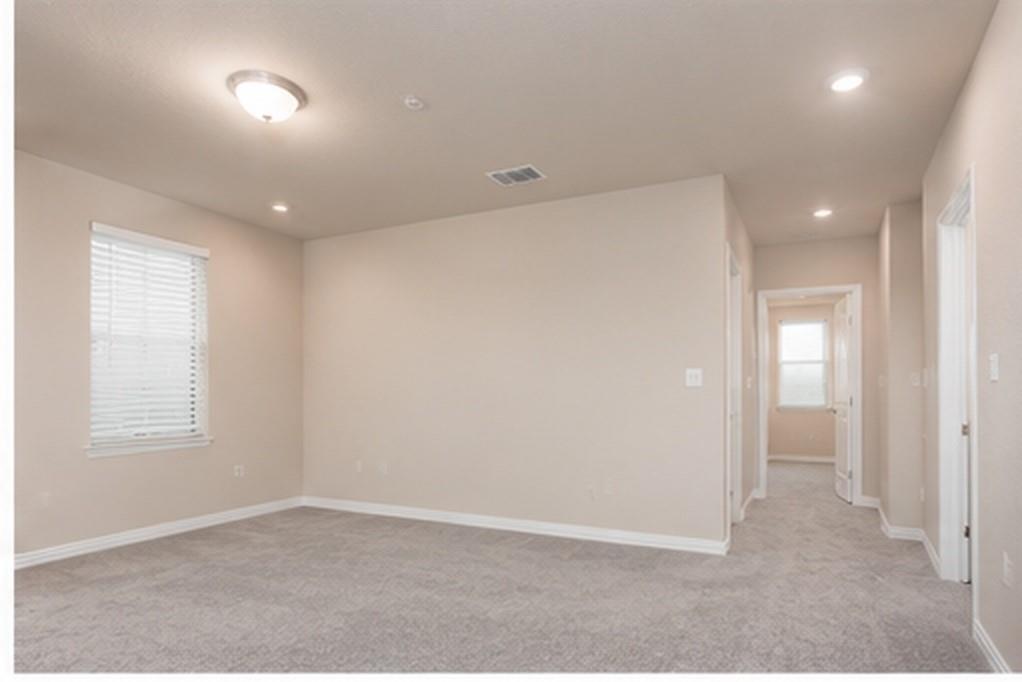 Interior room featuring neutral wall tones, plush wall-to-wall carpeting, recessed lighting, and a window with horizontal blinds