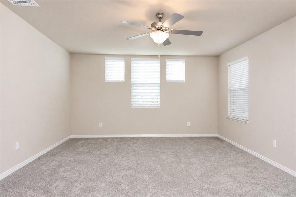 Neutral wall tones, carpeted flooring, multi-pane window configuration, and a central ceiling fan with integrated lighting