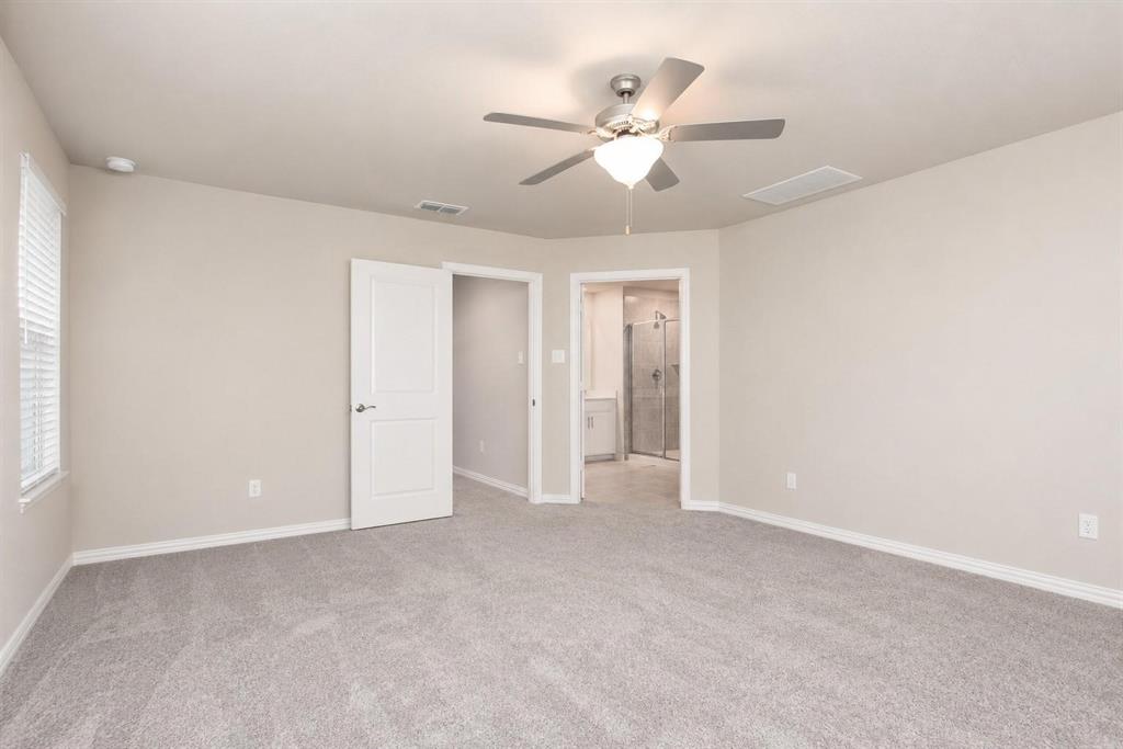 Neutral-toned interior featuring plush carpeting, a central ceiling fan with integrated lighting, and white paneled doors
