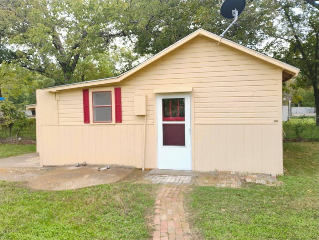 Amazing clean and comforatble space home is with exterior featuring horizontal lap siding, red window shutters, a white storm door, and a brick walkway, ready for your hanging of your welcome-to-my home wreath.
