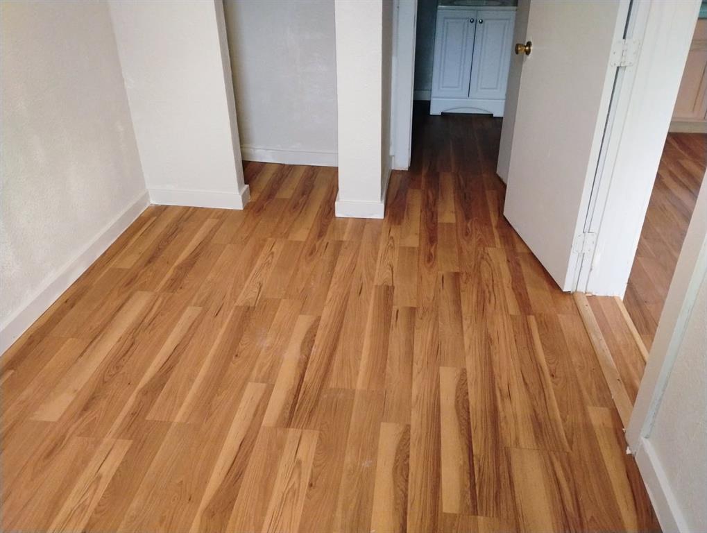 Wood-finish flooring throughout, featuring neutral wall tones and white trim