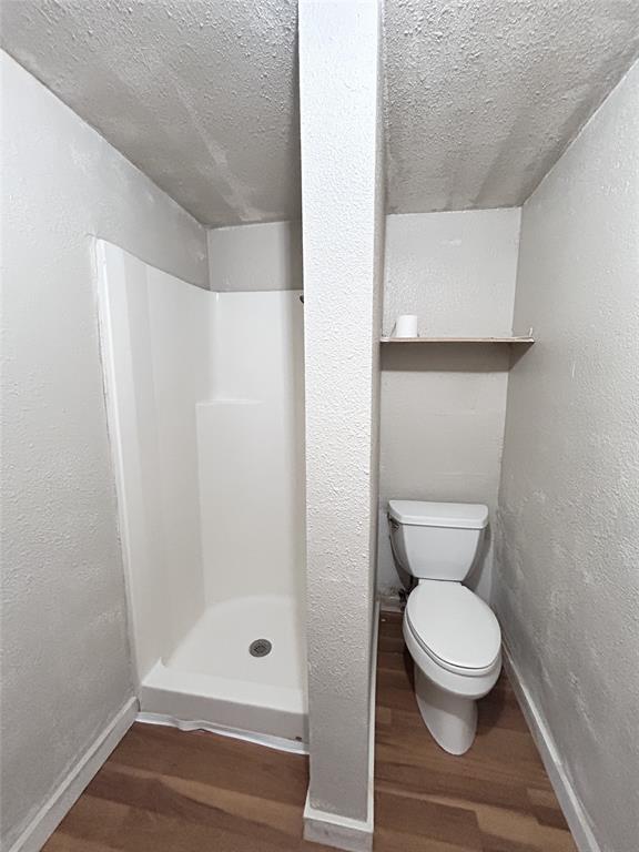 White molded shower surround with a centered pillar divider, wall-mounted shelving