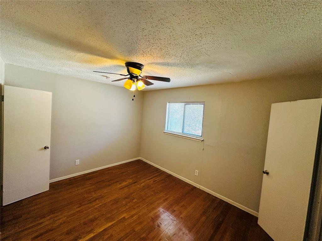 Wood-finish flooring, ceiling fan with integrated lighting, and dual doors