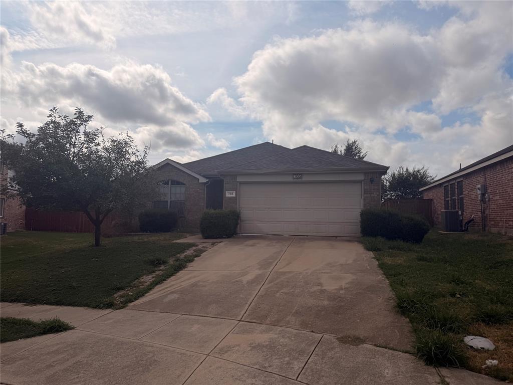 Single-story brick exterior featuring an attached two-car garage, concrete driveway, and arched window detailing Single-story brick exterior featuring an attached two-car garage, concrete driveway, and arched window detailing