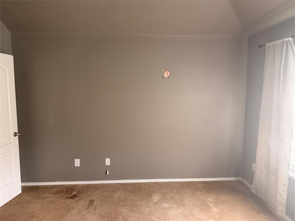 Room featuring wall-to-wall carpeting, neutral interior paint, and a multi-panel door