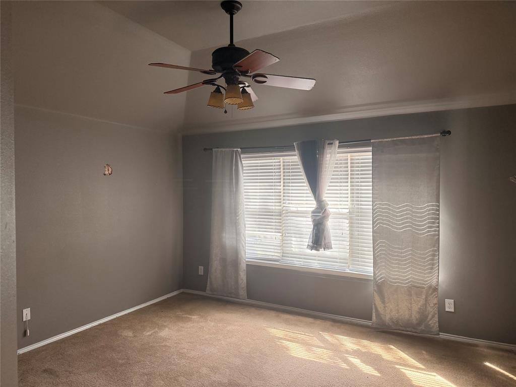Vaulted ceilings featuring a multi-blade ceiling fan with integrated lighting and a window with horizontal blinds Vaulted ceilings featuring a multi-blade ceiling fan with integrated lighting and a window with horizontal blinds