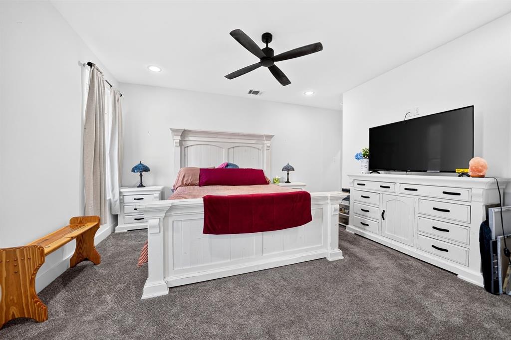 Spacious interior featuring recessed lighting, gray carpeting, and a matte black ceiling fan