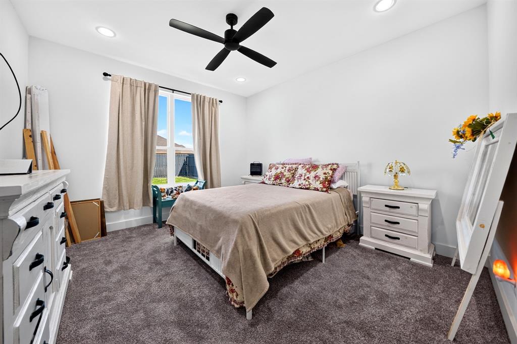 Neutral-toned interior featuring plush carpeting, recessed lighting, and a modern black ceiling fan