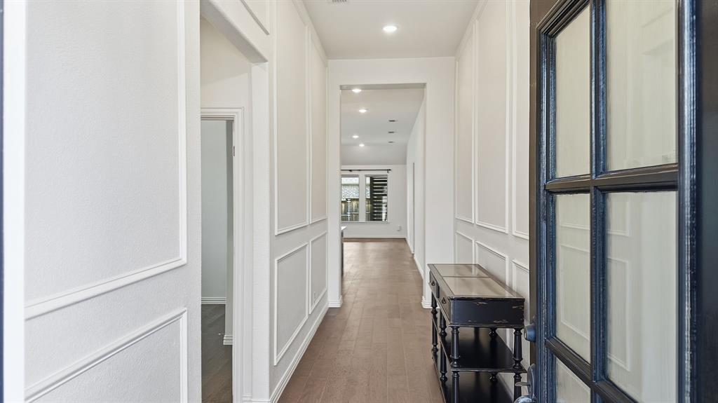 Entryway featuring wainscoting detail, wood-finish flooring, recessed lighting, and a multi-pane glass-inset door