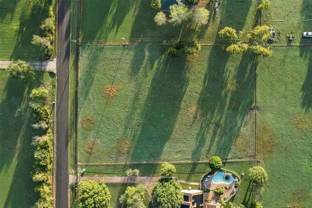 Expansive rectangular lot featuring established perimeter fencing, scattered mature trees, and direct paved road frontage Expansive rectangular lot featuring established perimeter fencing, scattered mature trees, and direct paved road frontage