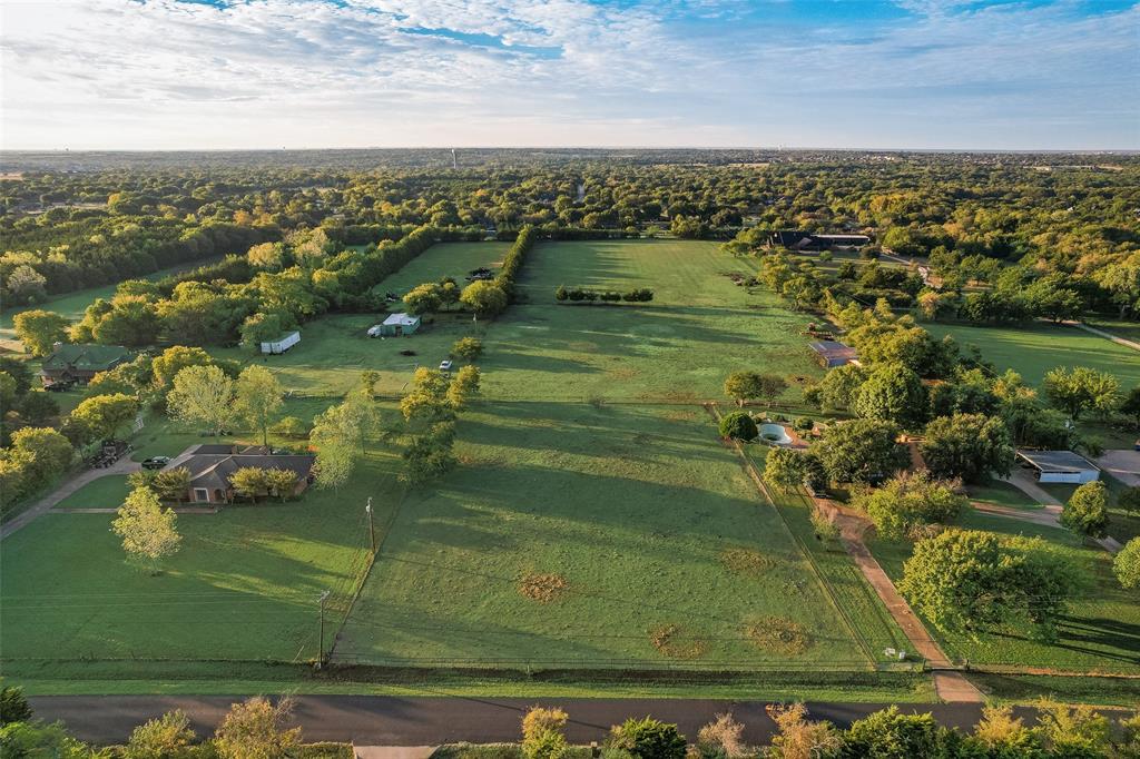 Expansive acreage featuring cleared pasture land, perimeter fencing, mature trees, and an on-site swimming pool