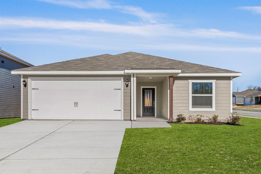 Single story home featuring a front lawn and a garage Single story home featuring a front lawn and a garage