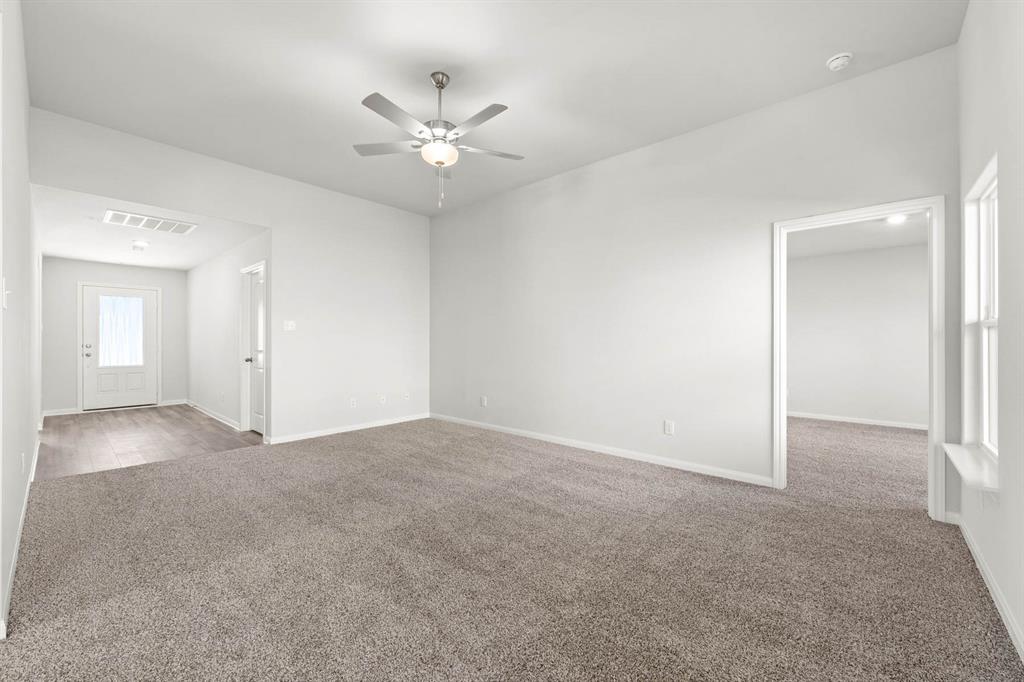 Carpeted empty room with ceiling fan Carpeted empty room with ceiling fan