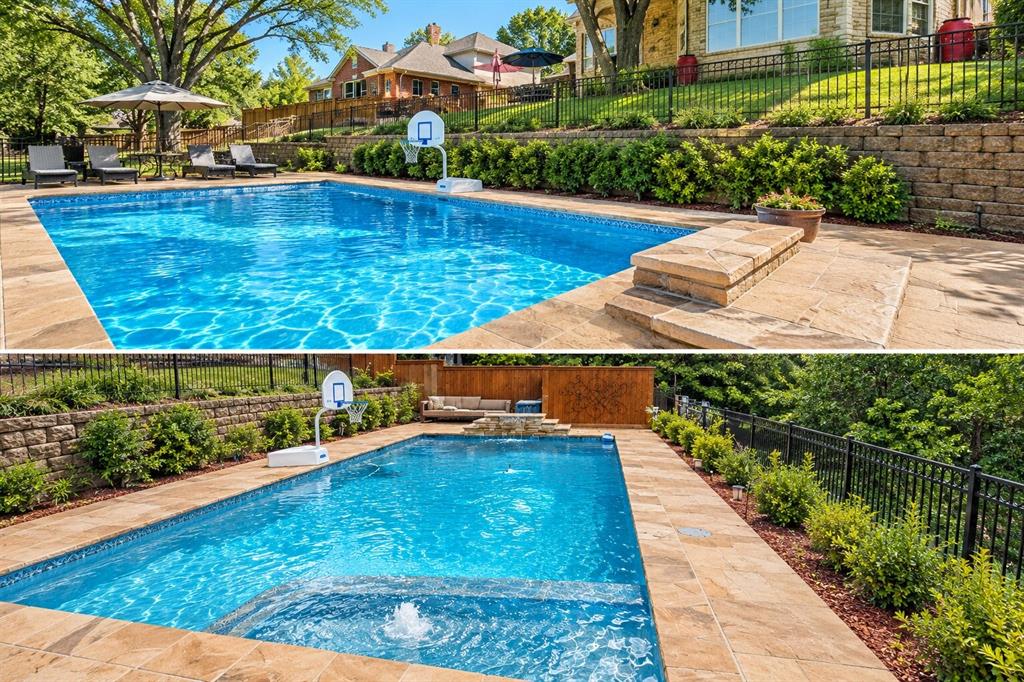 In-ground swimming pool featuring a built-in water feature, stone paver decking, decorative stone retaining walls, and perimeter metal fencing