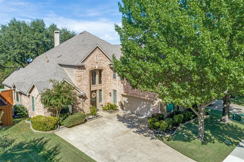 Multi-story brick exterior featuring a multi-gabled roofline, an arched entryway, and an attached multi-car garage