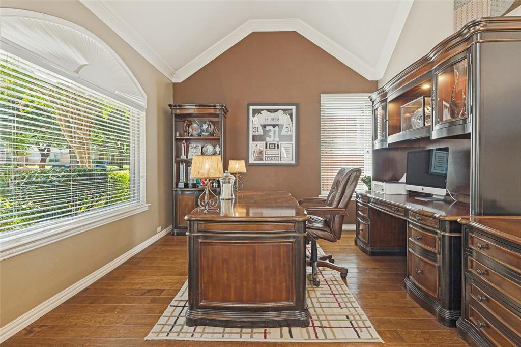 Vaulted ceilings, wood-finish flooring, built-in cabinetry, and an arched picture window