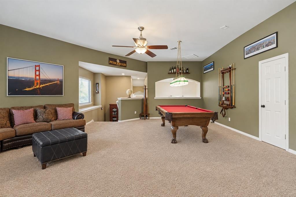 Open-concept room featuring a vaulted ceiling, ceiling fan with integrated lighting, wall-recessed arched niche, and neutral wall-to-wall carpeting