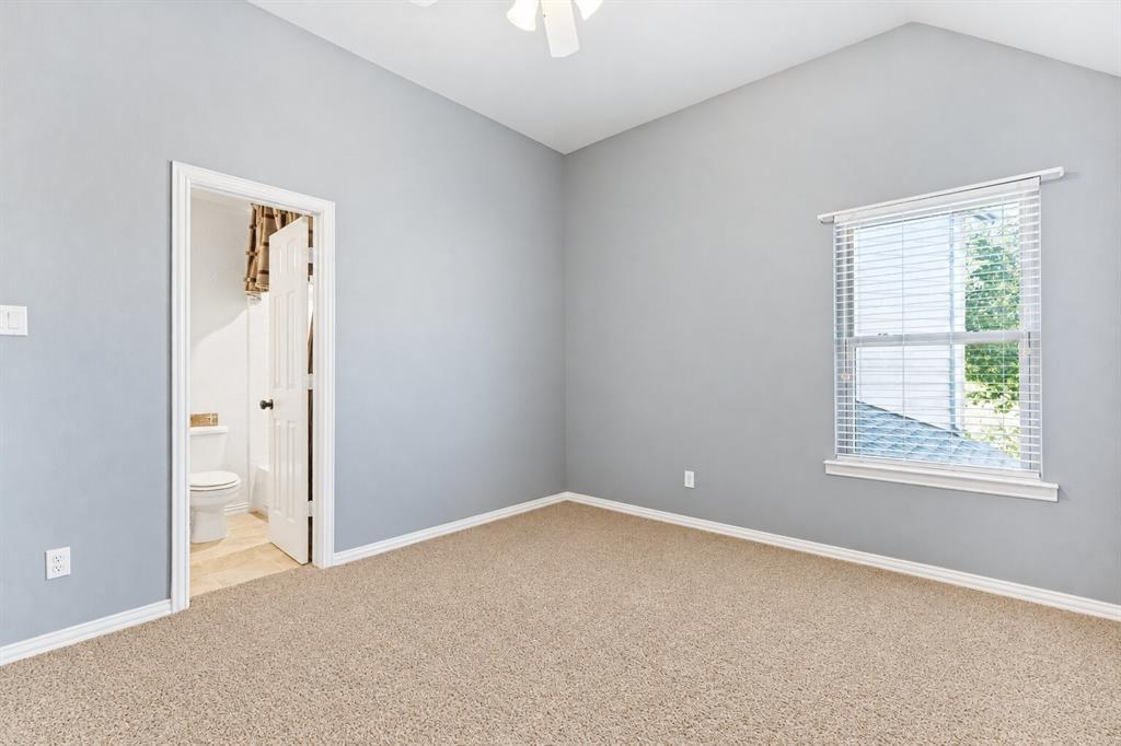 Vaulted ceilings, neutral carpeting, light-toned wall paint, integrated ceiling fan, and horizontal window blinds