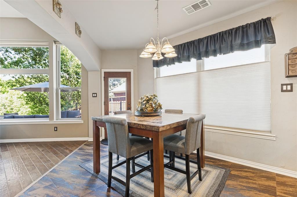 Wood-finish flooring, multi-pane windows with cellular shades, and a polished metal multi-bulb chandelier