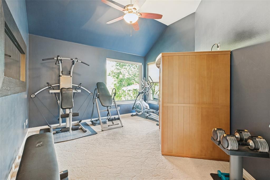 Vaulted ceilings, built-in wooden sauna, ceiling fan, and large windows providing natural light