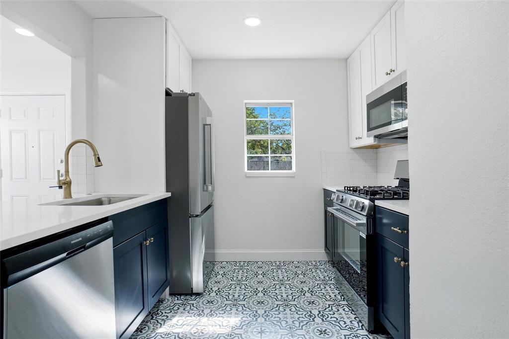 Kitchen with new cabinets, appliances and quartz countertops and decorative ceramic tile floor.