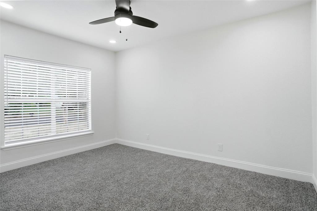 Primary bedroom with new carpet and remote control ceiling fan