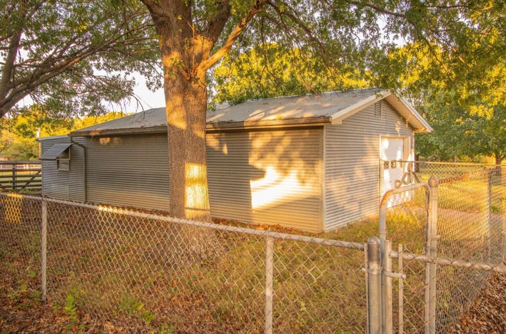 Detached structure with corrugated metal siding, metal roof, and chain-link fencing