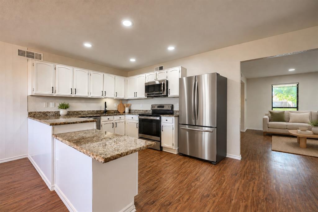 Kitchen featuring white cabinetry, stone-surface countertops, wood-finish flooring, recessed lighting, and stainless steel appliances