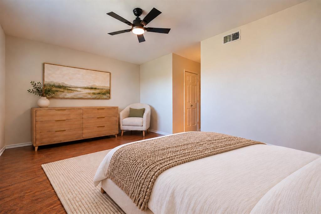 Wood-finish flooring, ceiling fan with integrated lighting, and a paneled interior door