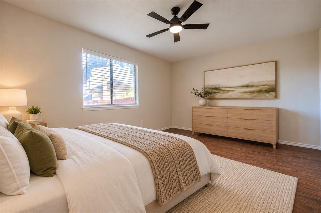 Wood-finish flooring, multi-blade ceiling fan with integrated lighting, and horizontal blinds