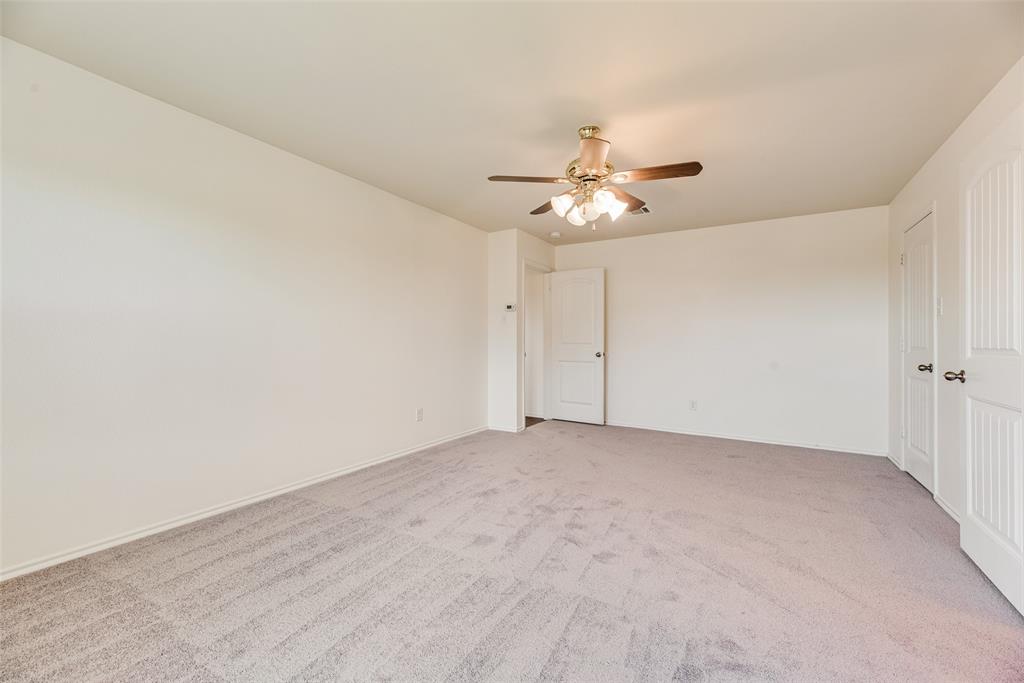 Neutral-toned wall-to-wall carpeting, multi-panel interior doors, and a ceiling-mounted light fixture with a fan