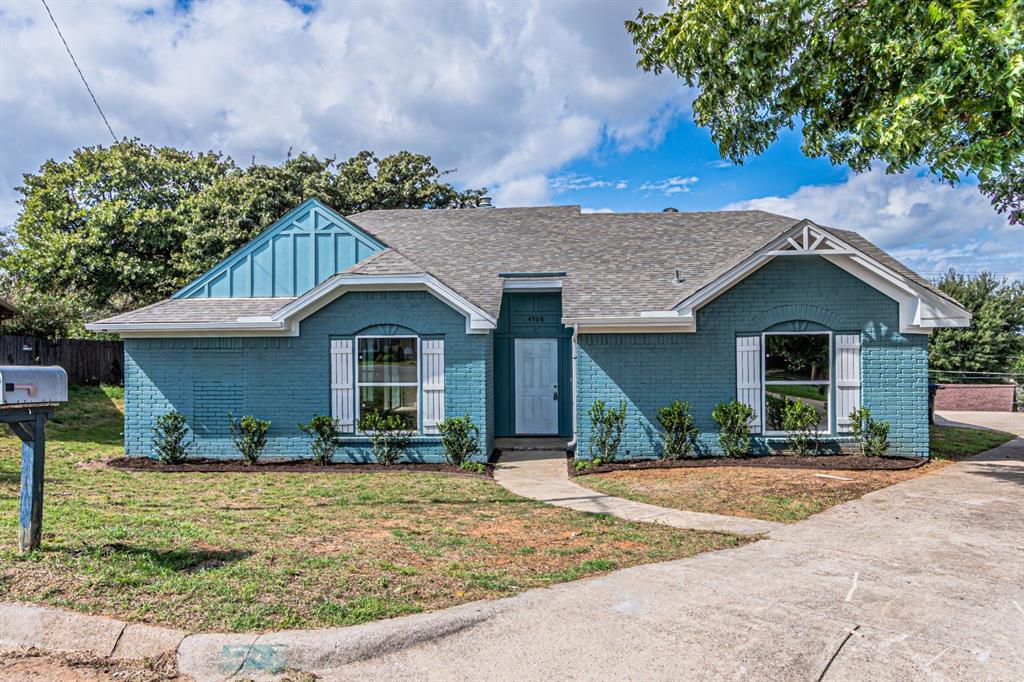 Painted brick exterior featuring gable roof lines, decorative shutters, and a concrete walkway