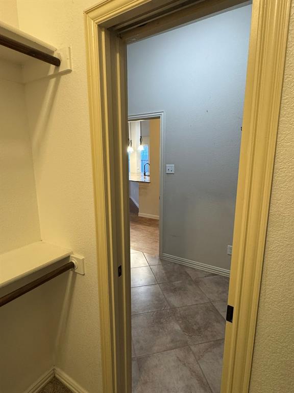 Built-in shelving and hanging rod with tile flooring
