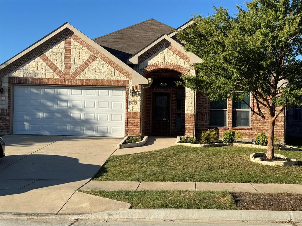 Exterior facade featuring a combination of brick and stone veneer, a multi-gabled roofline, an arched entryway, and a concrete driveway