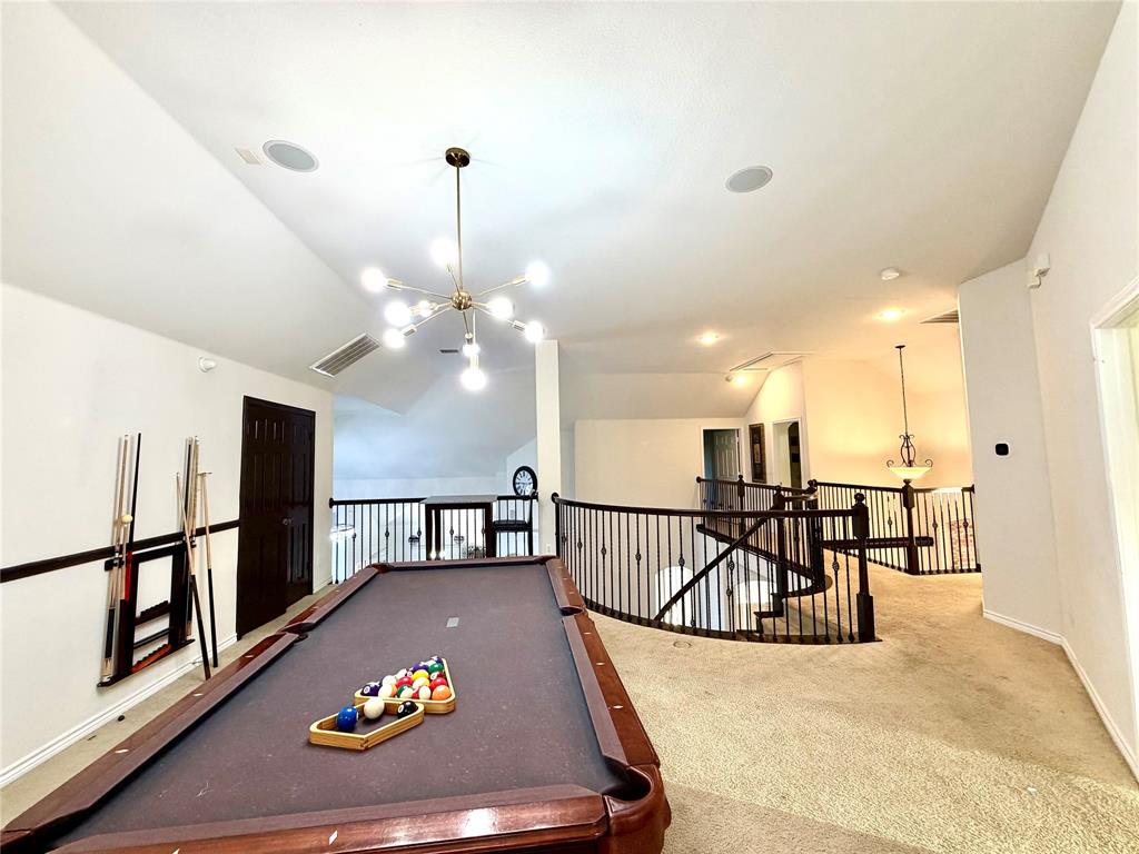 Vaulted ceilings featuring a multi-arm sputnik chandelier, metal baluster railings, and recessed lighting